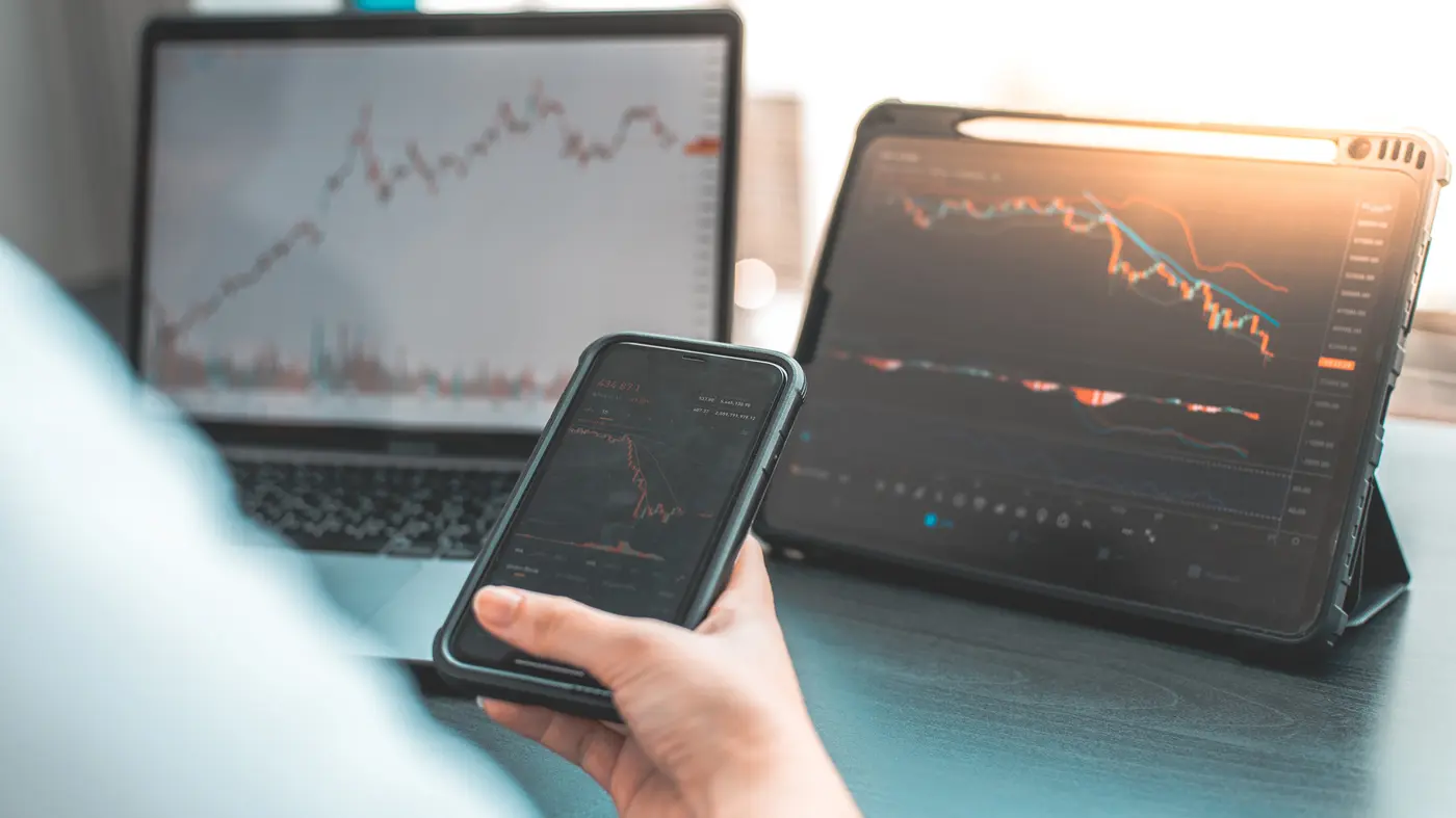 Trading charts on a phone, tablet and laptop